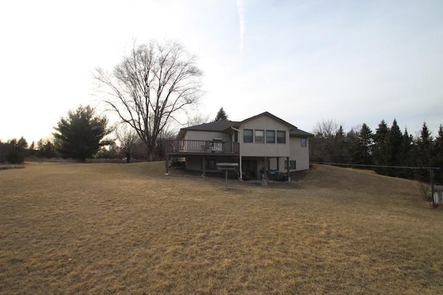 rear view of property with a wooden deck and a lawn