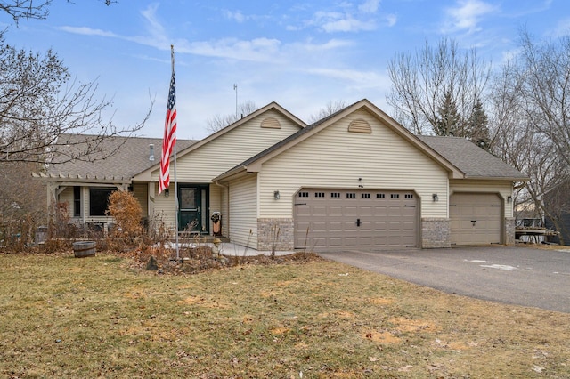 ranch-style home with driveway, a front yard, a garage, and a shingled roof