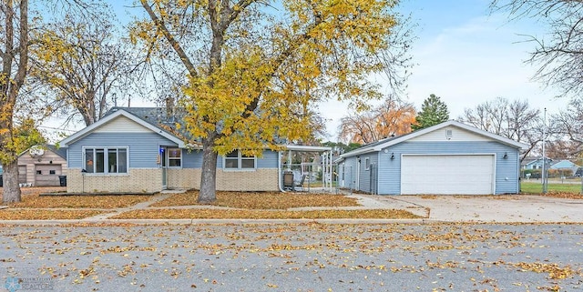 single story home with a detached garage, brick siding, and an outbuilding