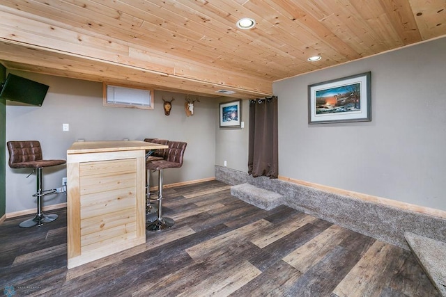 bar with dark wood finished floors, wooden ceiling, a dry bar, and baseboards