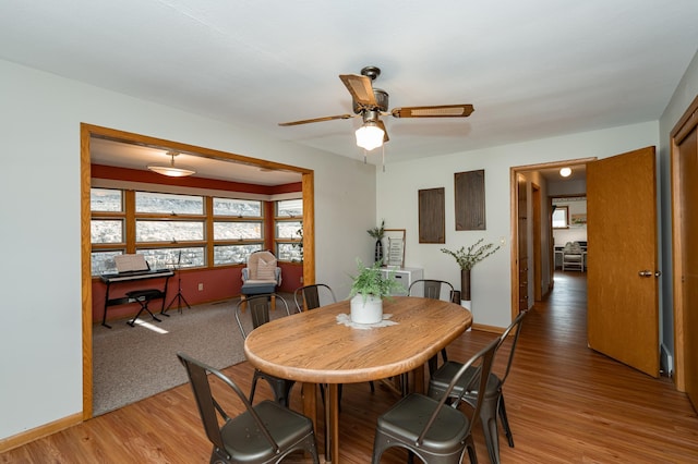 dining space with ceiling fan, baseboards, and light wood-style flooring