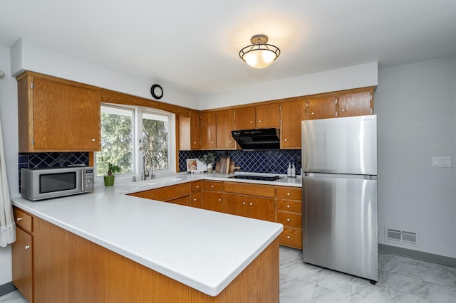 kitchen featuring visible vents, under cabinet range hood, appliances with stainless steel finishes, marble finish floor, and a sink