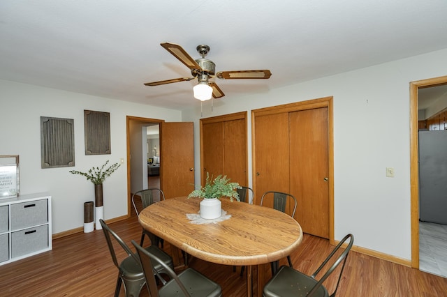 dining room with baseboards, wood finished floors, and a ceiling fan