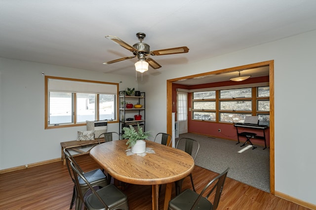 dining space with light wood finished floors, a ceiling fan, and baseboards