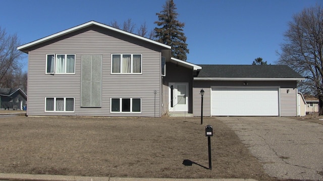 split level home featuring aphalt driveway and an attached garage