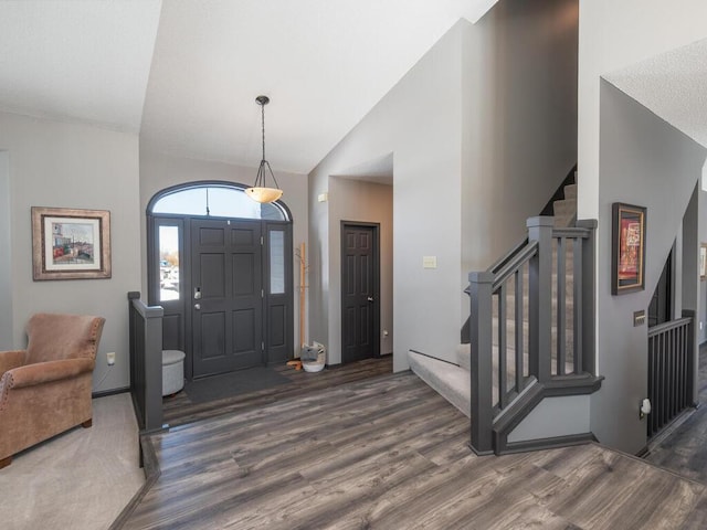 entryway featuring stairs, wood finished floors, and high vaulted ceiling