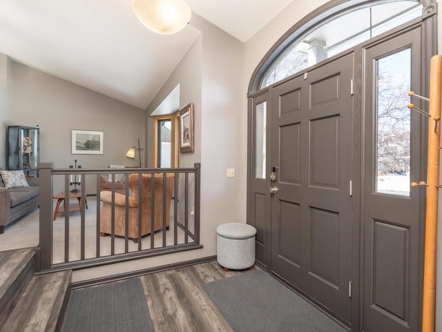 foyer entrance with lofted ceiling and wood finished floors