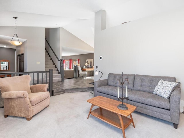 living room featuring stairway, high vaulted ceiling, and carpet floors