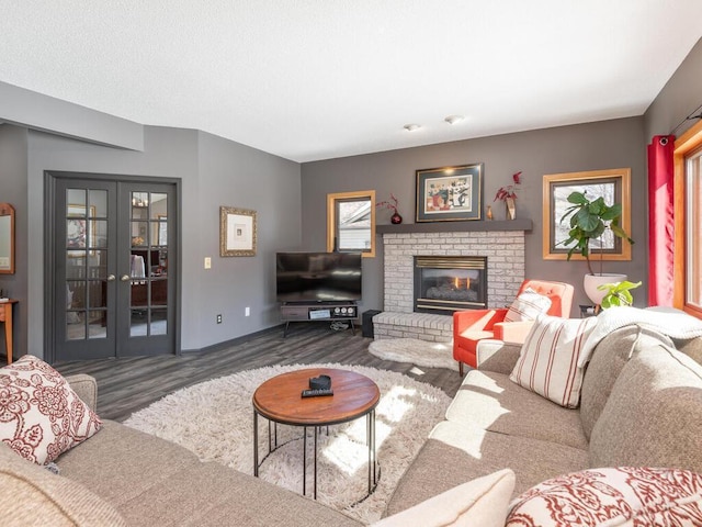 living room featuring a fireplace, wood finished floors, and french doors