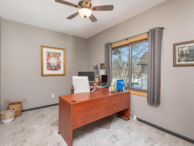 carpeted home office with baseboards, a textured ceiling, and a ceiling fan