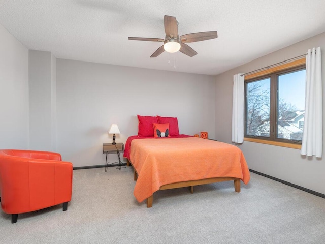 bedroom featuring baseboards, carpet, a ceiling fan, and a textured ceiling