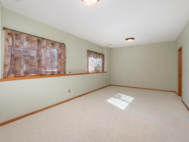 empty room featuring baseboards and carpet