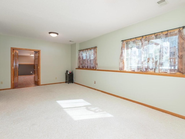 unfurnished room with visible vents, carpet floors, and baseboards