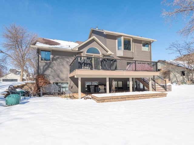 snow covered house featuring stairway