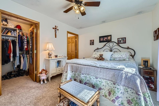 bedroom with a spacious closet, ceiling fan, a closet, and carpet