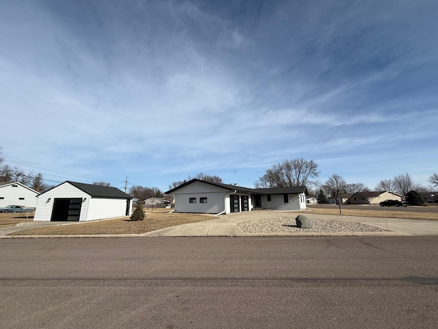 view of front facade featuring a garage, driveway, and an outdoor structure