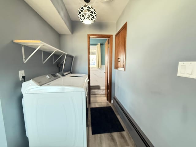 laundry room featuring laundry area, washing machine and dryer, and wood finished floors