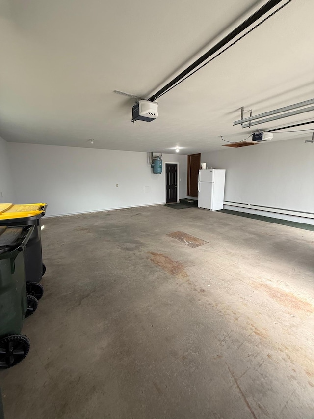 garage with a garage door opener, freestanding refrigerator, and a baseboard radiator