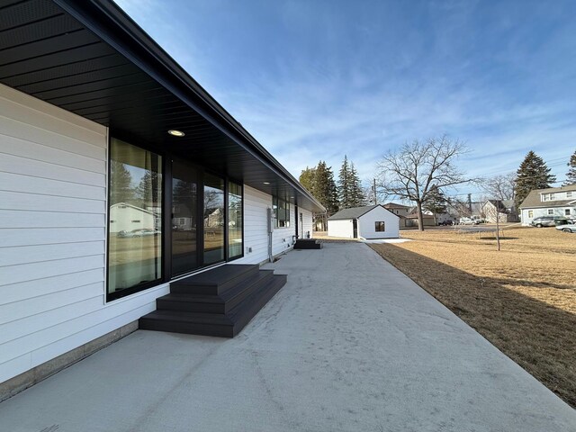 view of home's exterior with an outbuilding, a residential view, a patio area, and entry steps