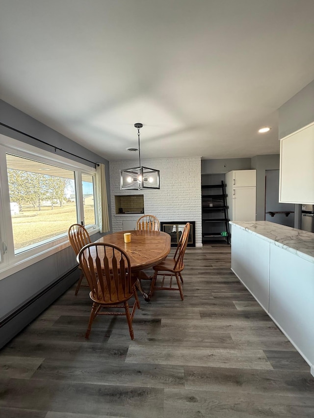 dining area with dark wood finished floors and baseboard heating