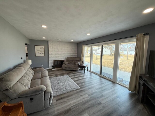 living room featuring recessed lighting, wood finished floors, and a fireplace