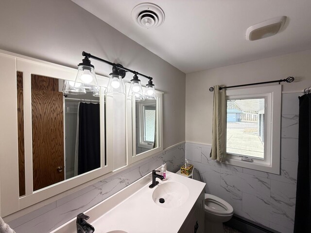 full bath featuring visible vents, a wainscoted wall, toilet, double vanity, and a sink