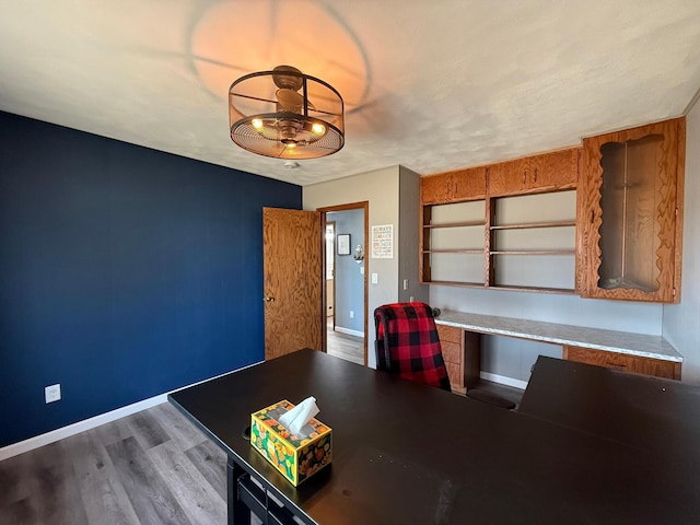 interior space with wood finished floors, baseboards, and built in study area