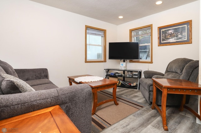 living room with recessed lighting, wood finished floors, and a textured ceiling