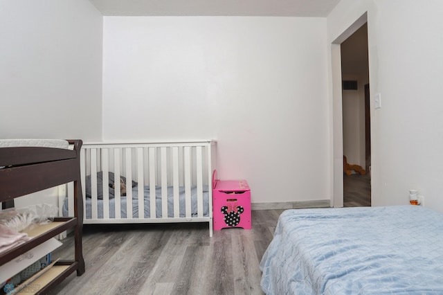 bedroom featuring baseboards and wood finished floors