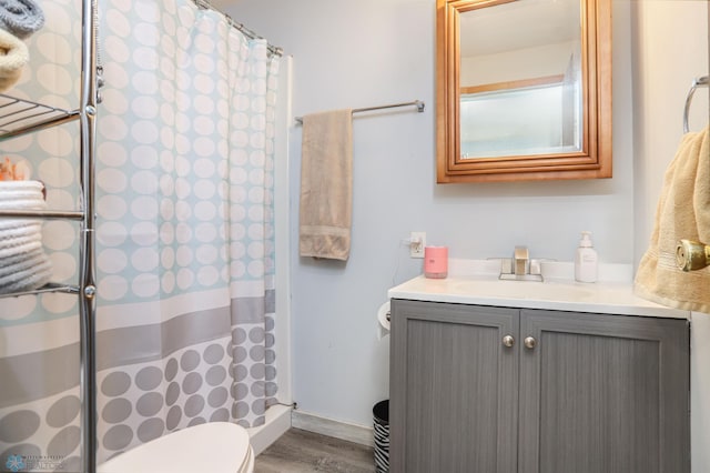 full bathroom featuring a shower with curtain, wood finished floors, vanity, and toilet