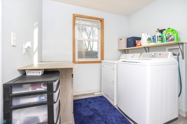 laundry area with laundry area, baseboards, and washer and clothes dryer