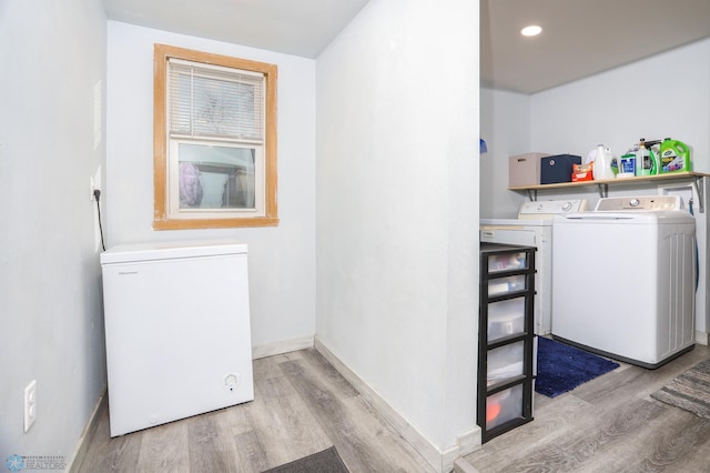 laundry area featuring washer and clothes dryer, wood finished floors, recessed lighting, baseboards, and laundry area