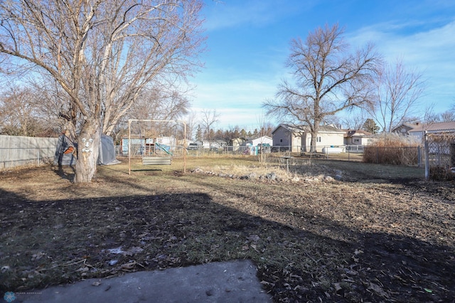 view of yard featuring a residential view, fence private yard, and a playground