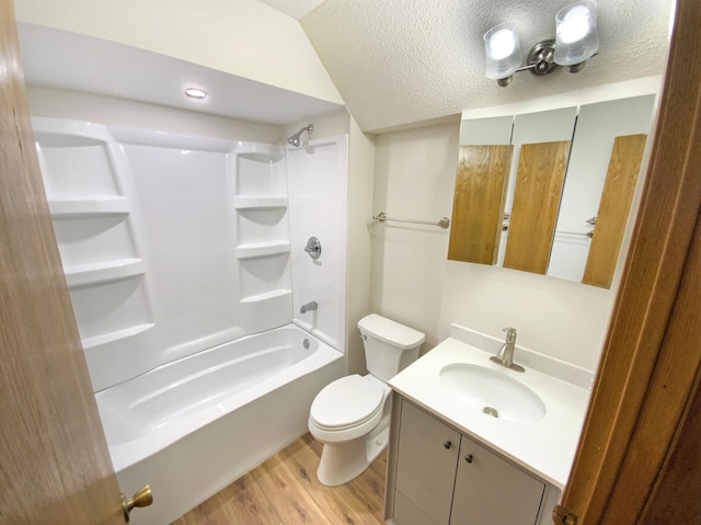 full bathroom featuring vanity, wood finished floors, bathtub / shower combination, a textured ceiling, and toilet