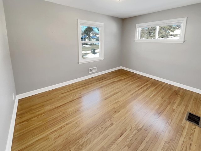 unfurnished room with visible vents, baseboards, and light wood finished floors