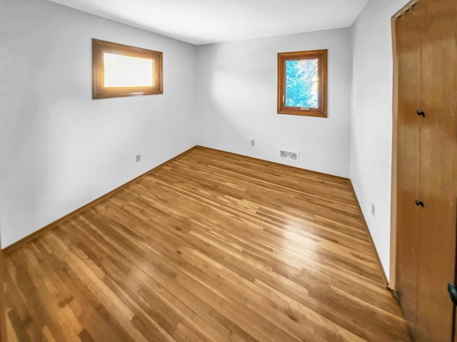 unfurnished bedroom with a closet, visible vents, and wood finished floors