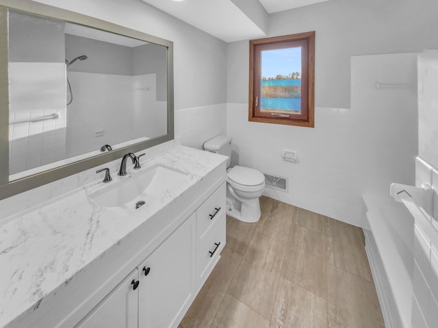 bathroom with vanity, visible vents, a wainscoted wall, a shower, and toilet