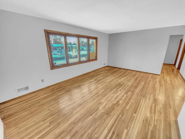 empty room featuring visible vents and light wood-style floors