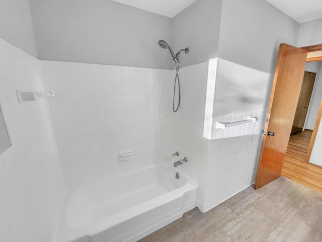 bathroom with bathtub / shower combination and tile walls