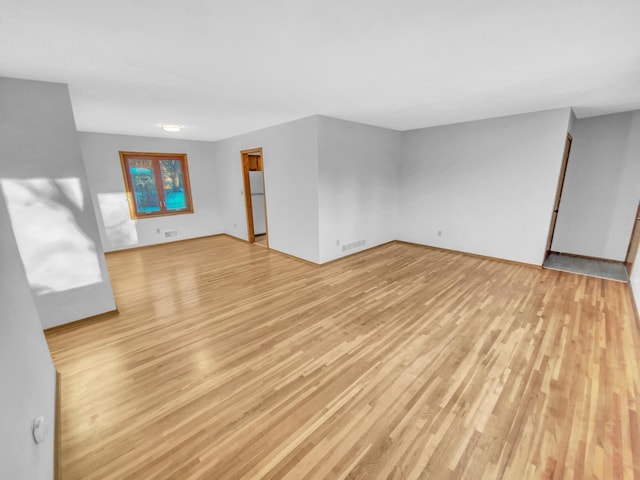 unfurnished living room featuring light wood finished floors and visible vents