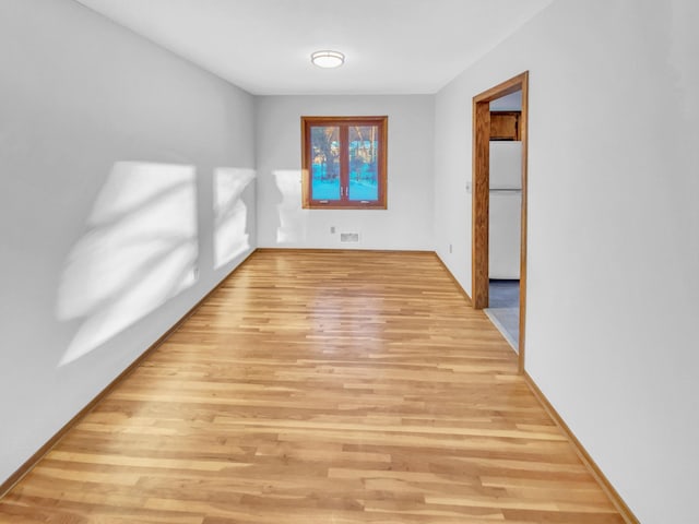 spare room featuring visible vents and light wood finished floors