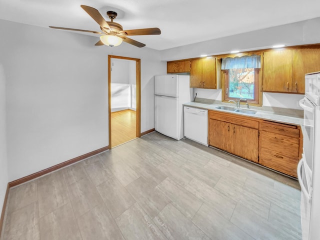 kitchen featuring a sink, white appliances, brown cabinets, and light countertops