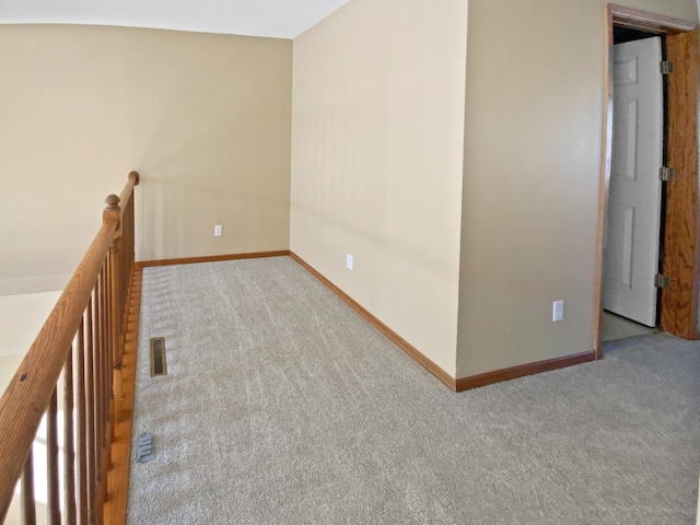 spare room with visible vents, baseboards, and carpet flooring