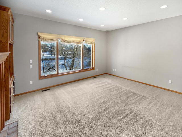 unfurnished living room featuring recessed lighting, visible vents, baseboards, and light colored carpet