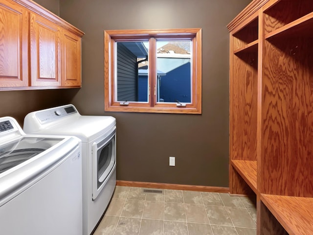 2412 132nd Ave NE, Blaine, MN 55449 - laundry area with baseboards, visible vents, light tile patterned flooring, cabinet space, and washer and clothes dryer