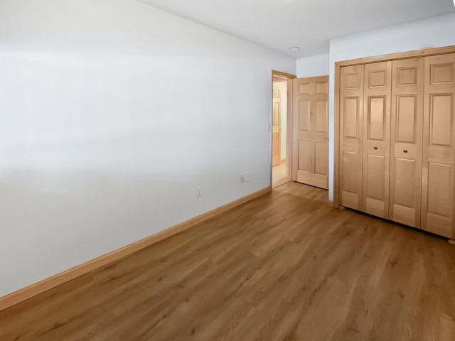 2412 132nd Ave NE, Blaine, MN 55449 - unfurnished bedroom featuring baseboards, a closet, and light wood finished floors