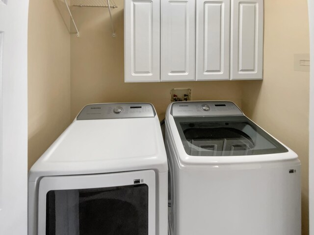 clothes washing area with cabinet space and independent washer and dryer