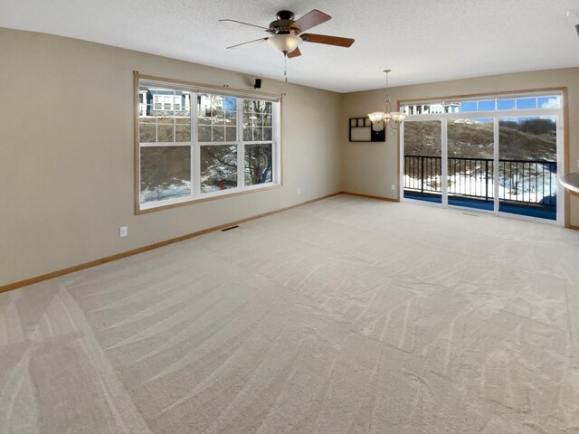 spare room with a wealth of natural light, baseboards, carpet floors, and a textured ceiling