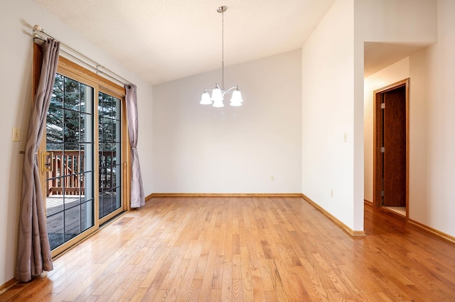 empty room with an inviting chandelier, light wood-style floors, and baseboards