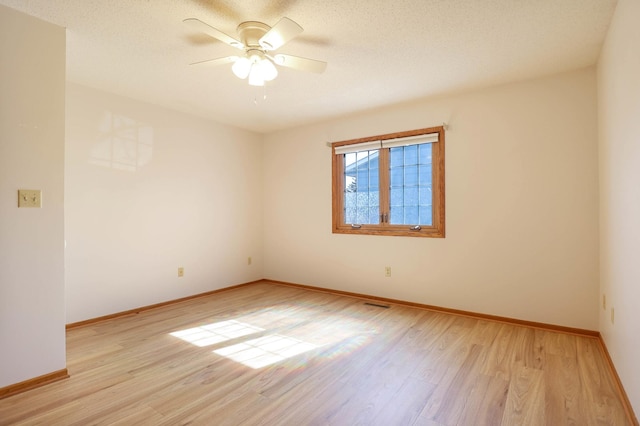 unfurnished room with visible vents, baseboards, ceiling fan, and light wood finished floors